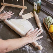 Italian Beechwood Rolling Pin and Dough Scraper Set on a counter, with a person rolling out dough, embodying precision and control for homemade pasta.