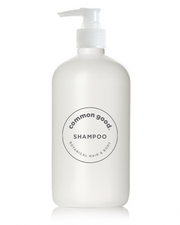 A white pump bottle labeled "Common Good" and "Botanical Shampoo & Conditioner" at the center, designed for botanical hair and body care. This all-natural shampoo has a clean and minimalistic appearance with black text, featuring a botanical blend that includes essential oils for a refreshing cleanse.
