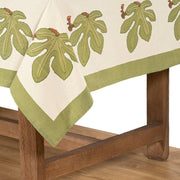 Couleur Nature - Fig Red & Green French Tablecloth: 71 x 71, showcasing fig leaf pattern on cream linen, draped over oak furniture, designed by Bruno Lamy.