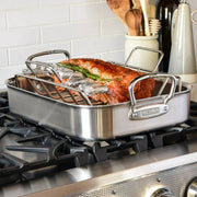 Hestan Provisions | Classic Roaster with Rack, 14.5 Inches, showcasing a seasoned roast with rosemary on a gas range, ideal for expert roasting and stovetop searing.