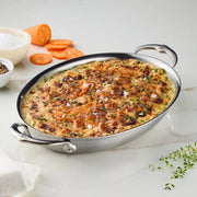Hestan Provisions | Medium Clad Oval Au Gratin with layered sweet potatoes in creamy sauce, topped with herbs, showcasing elegant design and functionality for culinary excellence.