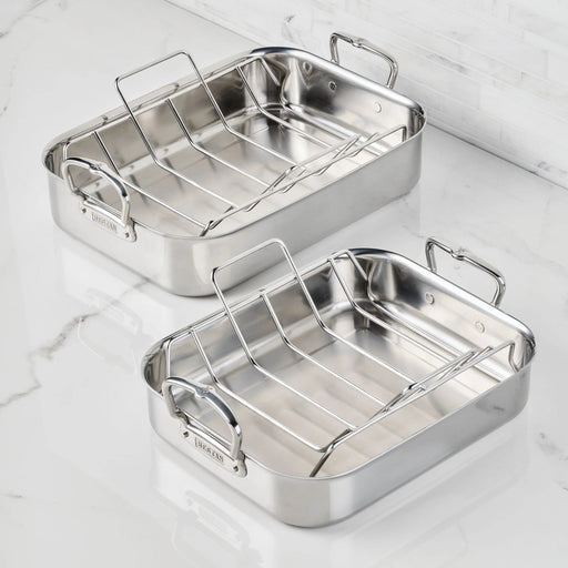 Hestan | Polished Clad Stainless Steel Roaster with Rack, Small, showcasing two durable roasters with removable racks on a marble countertop, ideal for Athens Cooks' culinary essentials.