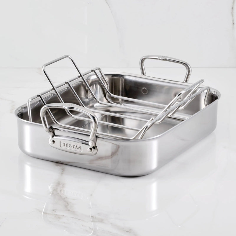 Hestan | Polished Clad Stainless Steel Roaster with Rack, Small, on a countertop, showcasing its durable stainless-steel construction and removable wire rack for optimal roasting performance.