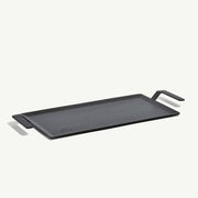Made In | Carbon Steel Griddle features a flat-top design with low sides, ergonomic handles, and fits over two burners for versatile stovetop or grill-top cooking.