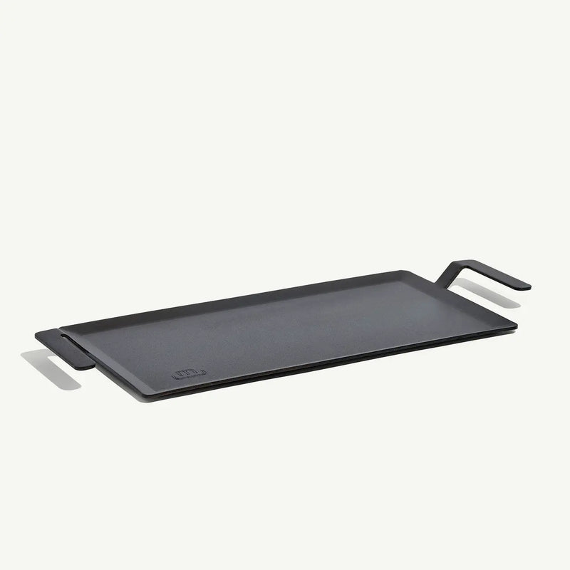 Made In | Carbon Steel Griddle features a flat-top design with low sides, ergonomic handles, and fits over two burners for versatile stovetop or grill-top cooking.