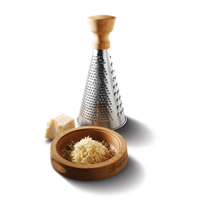 Boska | Table Grater Oslo with a wooden handle, shown with a small wooden bowl of freshly grated cheese and a wedge of hard cheese beside it.