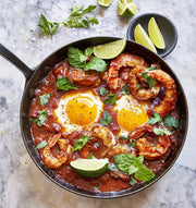 Villa Jerada - Kefta Rub - 50g enhances shakshuka with sautéed shrimp, fresh herbs, and lime wedges, reflecting Moroccan culinary influences.