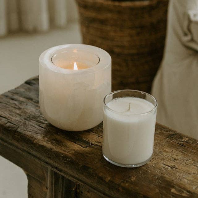 Last Candle Co - White Onyx Refillable Candle: A lit marble vessel and glass container candle on rustic wood, highlighting unique stone veining and luminous glow.