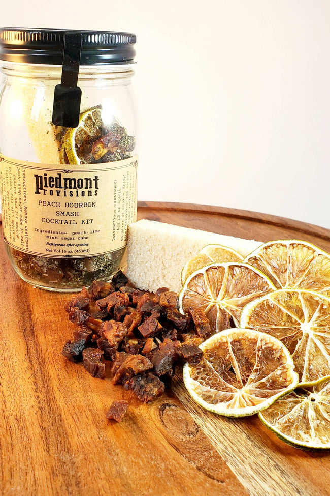 Piedmont Provisions Bourbon Peach Smash Cocktail Infusion Kit in a glass jar, featuring dried lemon slices for easy cocktail crafting.