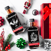 Runamok - Holiday Spice Infused Maple Syrup 250ml bottles on marble, surrounded by festive Christmas decor including ribbons, ornaments, and a nutcracker, ideal for holiday gifting.