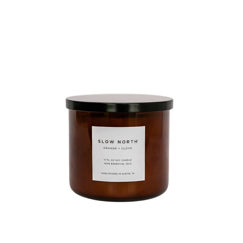 Slow North - Orange + Clove - Signature 3-Wick Non-Toxic Candle, featuring an amber-brown glass jar with a black lid, hand-poured in Austin, TX.