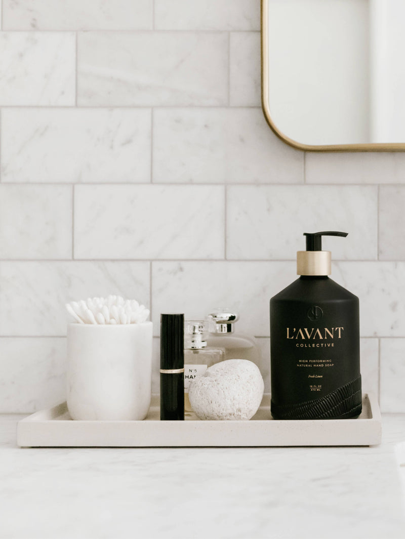 L'AVANT Collective - Fresh Linen Hand Soap in a matte black glass bottle on a tray, exemplifying eco-luxe style for elegant handwashing.