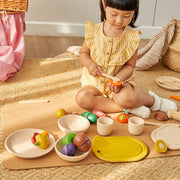PlanToys Kids Pretend Playtime Tableware Toy Set, featuring a young girl engaging with toy bowls and cups, perfect for imaginative play.