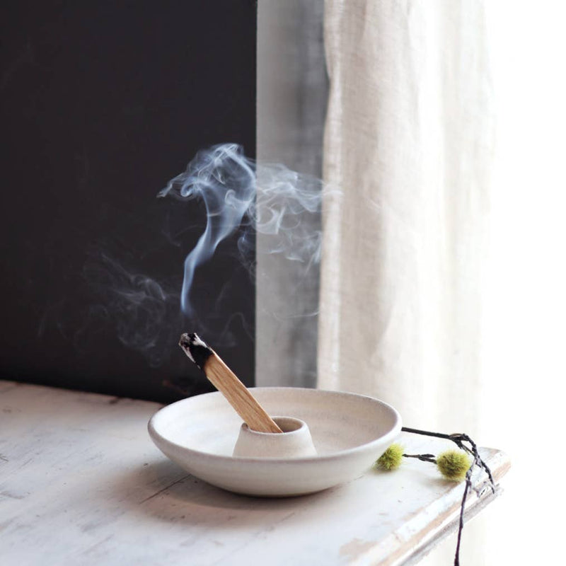 Gravesco Pottery - Palo Santo Burning Ritual Dish: Black, showcasing a partially burned smudge stick, delicate buds beside, on a wooden surface, embodying mindful, handcrafted elegance.