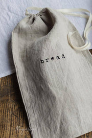 MagicLinen - Printed linen bread bag with bread logo, designed to keep bread fresh, featuring a drawstring closure and loop for hanging.