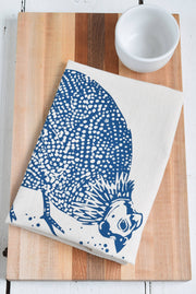 Hearth and Harrow - Organic Cotton Guinea Hen Tea Towel in Navy Blue, folded on a wooden board with a white ceramic bowl nearby, showcasing its unique bird design.