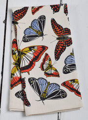 Hearth and Harrow - Butterfly Tea Towel, organic cotton, 30x30, featuring red, yellow, blue butterflies on cream, folded on white wooden surface.