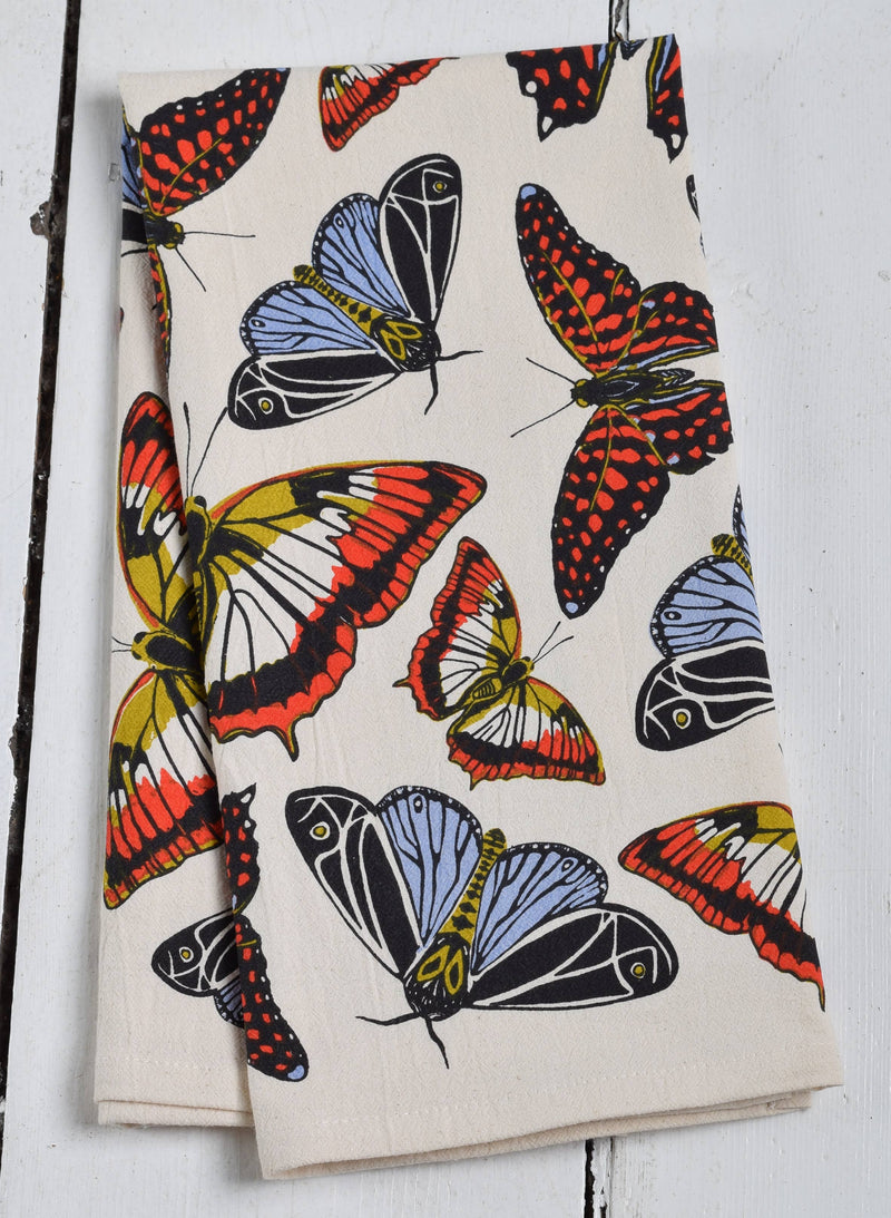 Hearth and Harrow - Butterfly Tea Towel, organic cotton, 30x30, featuring red, yellow, blue butterflies on cream, folded on white wooden surface.