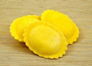 Nicola's Marketplace - Pork Osso Buco Ravioli, featuring three yellow pasta parcels filled with braised pork shanks and Parmigiano Reggiano, reflecting authentic Italian culinary tradition.