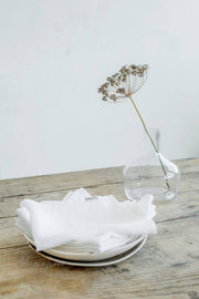 Set of 2 linen napkins on a table with a flower in a vase, ideal for versatile and stylish table decor.