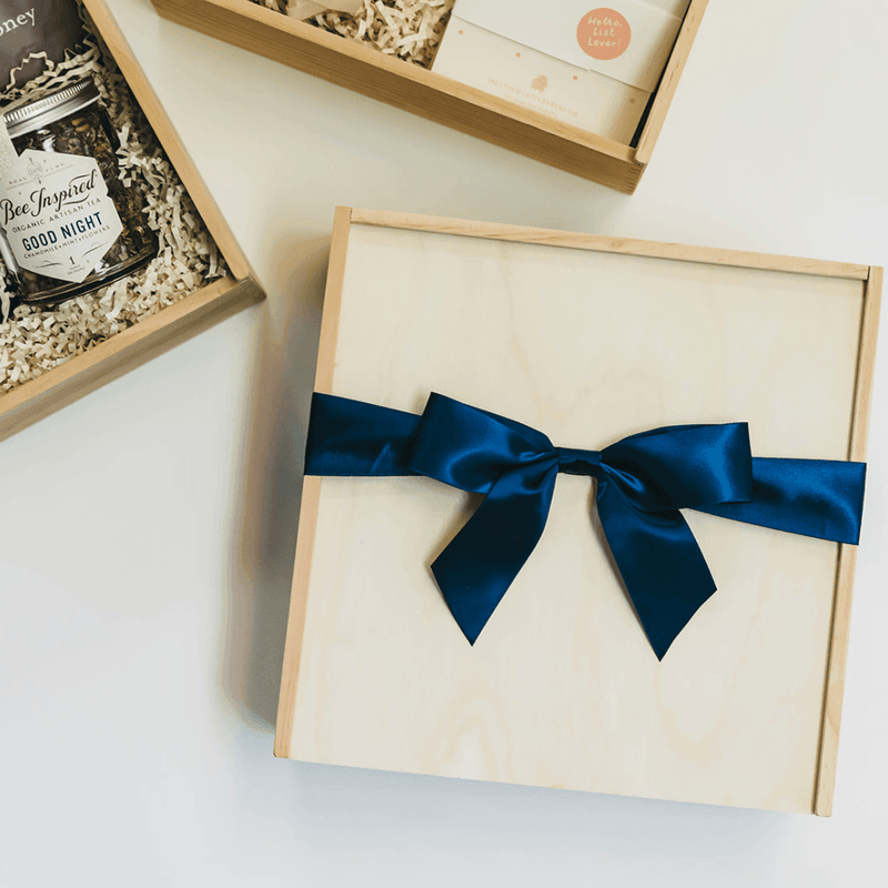 Giften Market - Wooden Gift Box Luxury Pine Keepsake with Lid - 10x10x5, showcasing a styled flat-lay with artisan tea, honey, and stationery in open crates.
