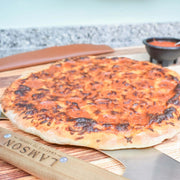 Lamson | 12 Pizza Rocker with Walnut Handles on a cutting board, showcasing its precision slicing tool for clean pizza cuts, ideal for Athens Cooks' curated kitchen collection.