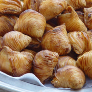 Nicola's Marketplace | Individual Mini Italian Sfogliatelle Pastries: golden, multi-layered pastries filled with ricotta and orange peel, showcasing flaky, clam-like shells.