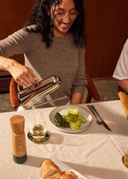 Holcomb Studio Oil Can being used to pour oil onto a salad, showcasing its precise elongated spout for controlled drizzling.