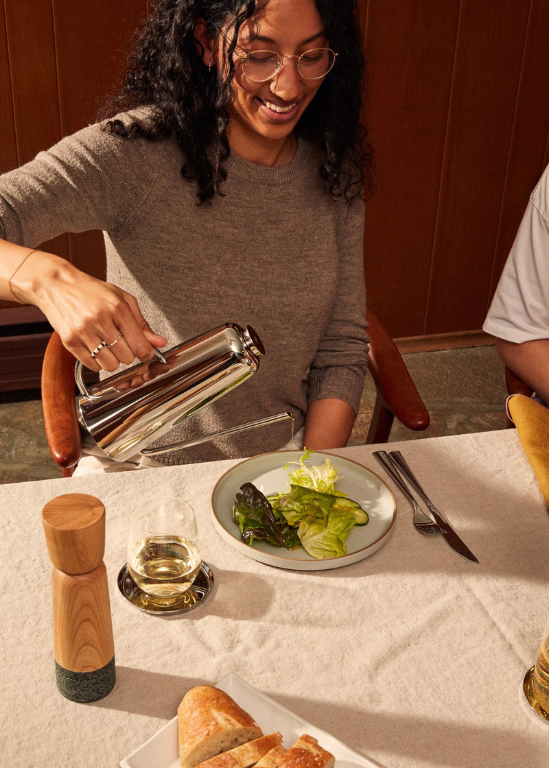 Holcomb Studio Oil Can being used to pour oil onto a salad, showcasing its precise elongated spout for controlled drizzling.
