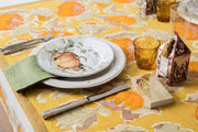 Pumpkin Orange & Mustard Tablecloth sets a festive fall scene with a pumpkin-patterned design, complemented by autumnal place settings for an elegant Thanksgiving table.
