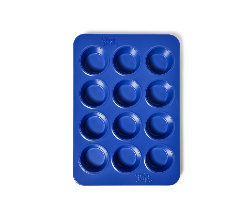 Great Jones | Stud Muffin - Blueberry: A nonstick, 12-hole muffin pan designed for even heat distribution and easy cleanup, ideal for baking muffins or cupcakes.