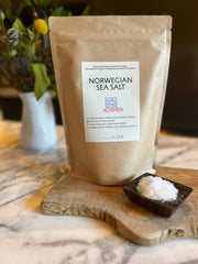 HAVSNØ Fine Kosher Norwegian Sea Salt in a kraft-paper pouch, on a wooden board, beside a dish of salt crystals; ideal for versatile kitchen use.