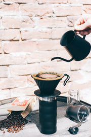 HARIO USA - V60 Metal Dripper: Silver on a pour-over setup, featuring a kettle, coffee grounds, and grinder, epitomizing Athens Cooks' curated kitchen tools.