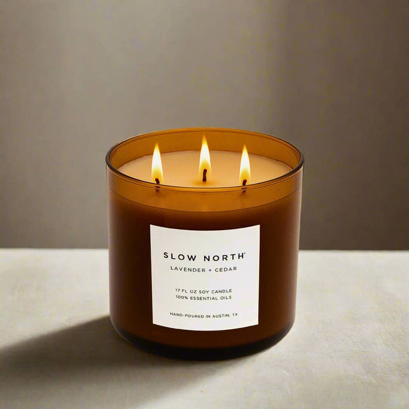 Slow North - Lavender + Cedar - Signature 3-Wick Non-Toxic Candle in amber jar, lit, with black lid, 17 fl oz, ideal for large spaces.
