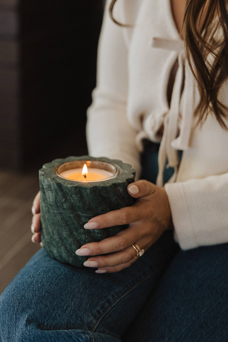 Person holding Last Candle Co - Emerald Green Marble Refillable Candle in dark-green stone vessel, showcasing its unique veining and roped design.