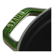 Staub | Round Cocottes - 7 qt Basil: Close-up of a green enamel handle and black interior, showcasing its craftsmanship for versatile cooking.