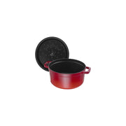 Staub | Round Cocottes - 7 qt Cherry, featuring a red cast-iron pot with two handles and a black underside lid, ideal for slow-cooking.