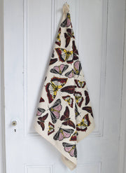 Hearth and Harrow - Butterfly Tea Towel, oversized 30x30, hangs on a door, showcasing eco-friendly, hand-printed butterfly designs on organic cotton.