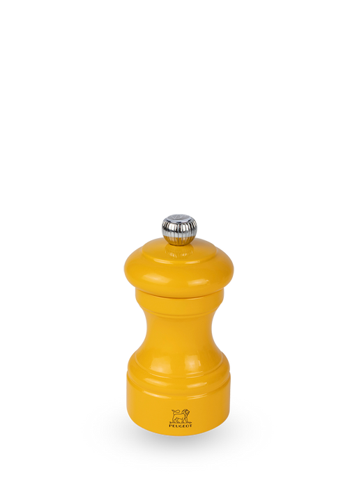 Peugeot | Bistro Pepper Mill, Saffron: A small, bright yellow, hourglass-shaped manual grinder with a metal knob and Peugeot logo, crafted sustainably in France.