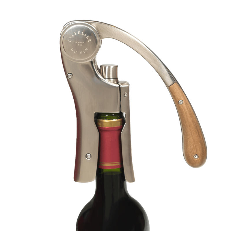 L'Atelier du Vin - USA - Lever Wine Opener - OENO MOTION TRESOR clamped on a wine bottle, showcasing its sleek design and efficient cork extraction mechanism.
