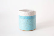 RachaelPots - Kitchen Utensil Holder: Sage. A small, cylindrical, hand-thrown ceramic vessel with speckled blue and white glaze, perfect for organizing kitchen utensils.