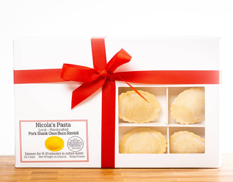 Nicola's Marketplace - Pork Osso Buco Ravioli in a gift box with a red ribbon, featuring fluted-edge ravioli visible through a clear window.