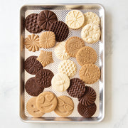 Nordic Ware | Honey Bees Cookie Stamps displayed on a tray of intricately designed cookies, showcasing bee, flower, and honeycomb patterns for delightful spring-themed baking.