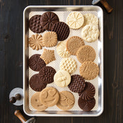 Nordic Ware | Heirloom Cookie Stamps displayed on a tray with cookies featuring intricate bee and flower designs, showcasing detailed patterns for baking enthusiasts.