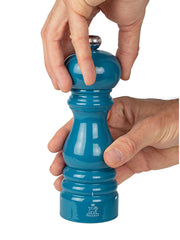 Peugeot | Paris u'Select Pacific Blue Lacquered Salt Mill, 7 inches, shown being used, highlighting its vibrant finish and ergonomic design for precise seasoning.