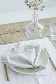 Set of 2 MagicLinen linen napkins on a table with fork and plate, showcasing elegant table decor, perfect for enhancing dining experiences.