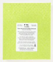 Three Bluebirds Swedish Dishcloths - Daisies on Green, featuring a paper with usage instructions, ideal for sustainable cleaning in your kitchen.