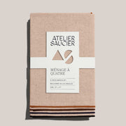 ATELIER SAUCIER - Dune Napkins | Set of 4: Four linen napkins with color-blocked trims, neatly tied with a branded belly band.