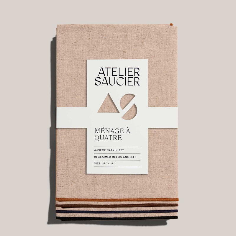 ATELIER SAUCIER - Dune Napkins | Set of 4: Four linen napkins with color-blocked trims, neatly tied with a branded belly band.