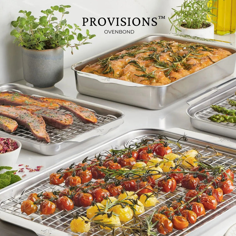 Hestan Provisions OvenBond Tri-Ply Bakeware Half Sheet Pan with roasted cherry tomatoes, rosemary, herb-topped focaccia, and sweet potatoes on elevated racks, showcasing premium craftsmanship.